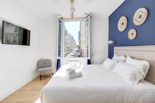 une chambre avec un lit blanc et une fenêtre dans l'établissement Pick A Flat's Apartment in Le Marais - Rue Saint Apoline, à Paris