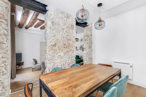 une salle à manger avec une table et des chaises en bois dans l'établissement Pick A Flat's Apartment in Le Marais - Rue Saint Apoline, à Paris