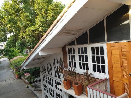 a house with a white fence and a porch at Nature Home in Phra Nakhon Si Ayutthaya