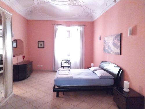 - une chambre avec un lit dans une pièce aux murs roses dans l'établissement Apartment Basile, à Palerme
