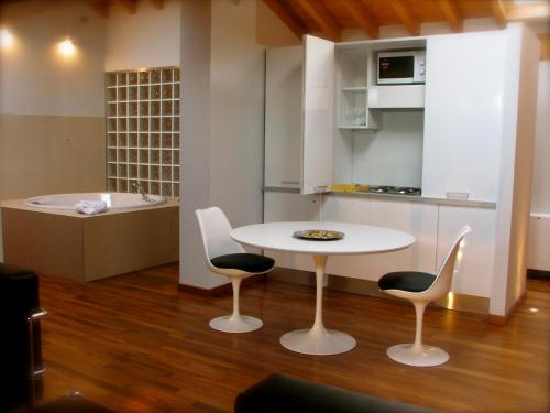 una cucina con tavolo, sedie e vasca di Parizzi Suites & Restaurant a Parma