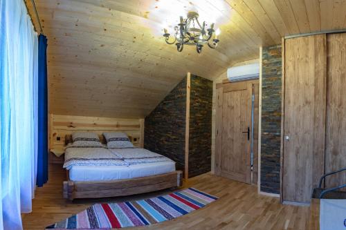 a bedroom with a bed and a chandelier at Apartmány Goral Podhájska in Podhájska