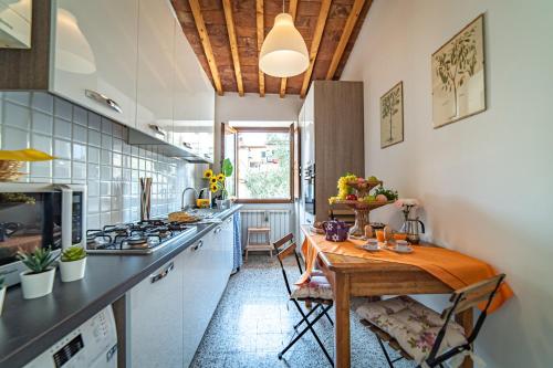 Oltrarno Apartment في فلورنسا: مطبخ مع طاولة خشبية في الغرفة