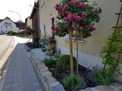 drzewo z kwiatami na boku budynku w obiekcie Ferienhaus Forstblick w mieście Betzenstein