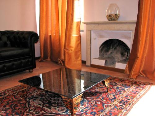 a living room with a fireplace and a glass table at Parizzi Suites & Restaurant in Parma
