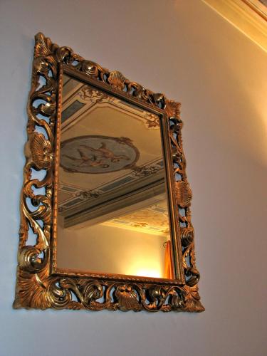 an ornate mirror hanging on a wall at Parizzi Suites & Restaurant in Parma