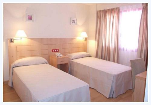 Cama o camas de una habitación en Hotel Villa de Zaragoza