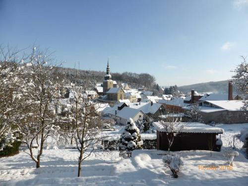 a village covered in snow with a church at Ferienwohnung Kunze in Obernsees