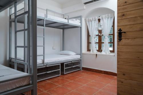 Zimmer mit 2 Etagenbetten und einem Fenster in der Unterkunft The White Balcao in Panaji