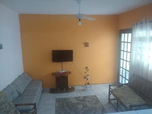 a living room with a couch and a flat screen tv at Apartamento em Angra dos Reis in Angra dos Reis