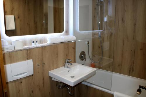 a bathroom with a sink and a shower and a mirror at Zum neuen Schwan in Walluf