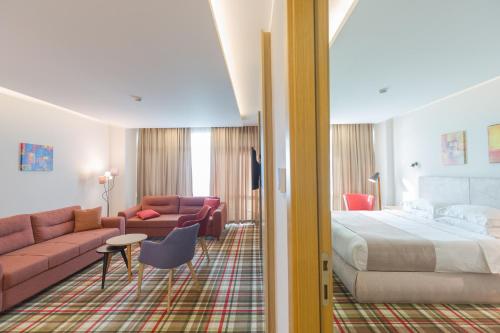 a hotel room with a bed and a couch at Best Western Premier Batumi in Batumi