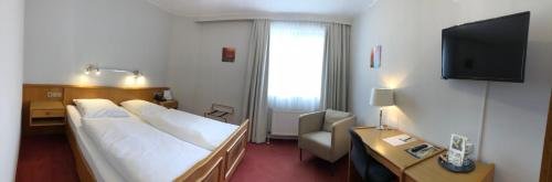 a hotel room with a bed and a television at Zum neuen Schwan in Walluf