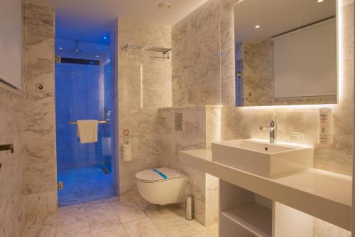 y baño con aseo, lavabo y ducha. en Hotel Napa Suites (Adults Only), en Ayia Napa