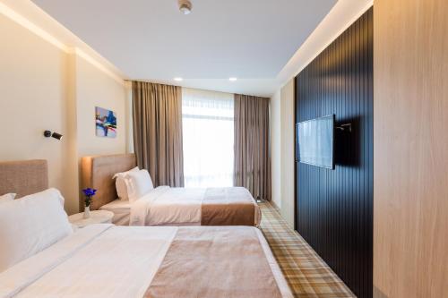 a hotel room with two beds and a television at Best Western Premier Batumi in Batumi