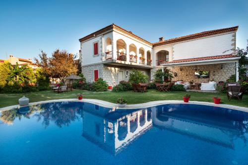 a large swimming pool in front of a house at Mercan Köşk in Alaçatı