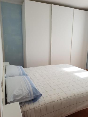 a bedroom with a large white bed and a window at CROTTO CARACO APPARTAMENTI BUNGALOW CHALET in Porlezza
