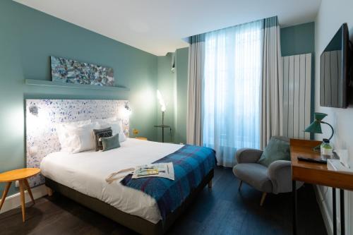 une chambre d'hôtel avec un lit et une chaise dans l'établissement 1er Etage Marais, à Paris