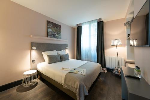 a hotel room with a bed and a desk at 1er Etage Marais in Paris
