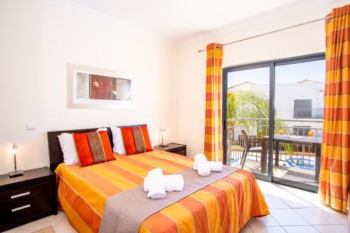 a bedroom with a bed and a balcony at Jardins de Pêra in Pêra