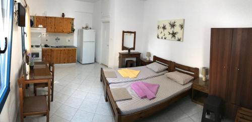 een slaapkamer met een bed met paarse servetten erop bij Asimina Studios in Donoussa