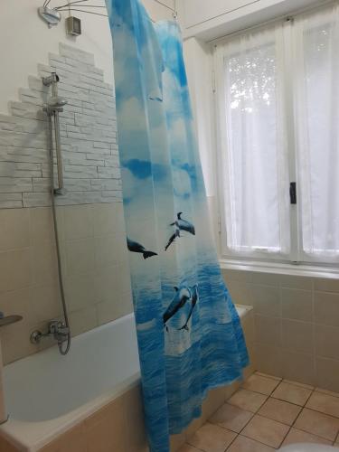 a shower curtain with dolphins on it in a bathroom at CROTTO CARACO APPARTAMENTI BUNGALOW CHALET in Porlezza