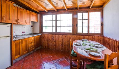 een keuken met een tafel, een koelkast en ramen bij Sunny studio Flat in Los Cristianos