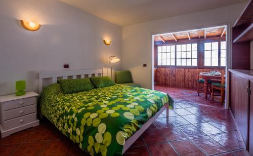 een slaapkamer met een bed met een groen dekbed bij Sunny studio Flat in Los Cristianos