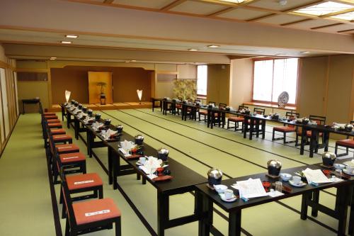 a large room with tables and chairs and a bowling alley at Mutsumikan in Gero