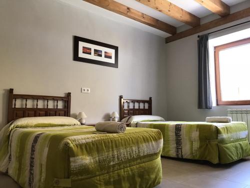 1 dormitorio con 2 camas y mantas verdes en Albergue Orion, en Castrojeriz