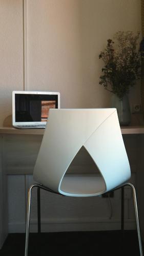 a white chair sitting next to a desk with a laptop at Hôtel d'Orsay Grand Matabiau in Toulouse