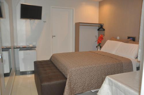 a hotel room with a bed and a television at Hotel Sempre Bahia in Salvador