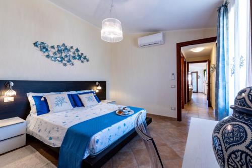 una camera da letto con un letto con lenzuola blu e bianche di La Casa delle Conchiglie a Villasimius