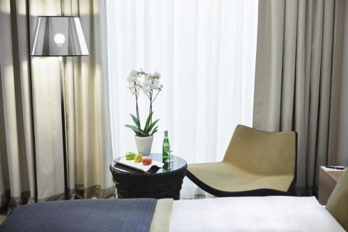 a hotel room with a bed and a table and a chair at Steigenberger Hotel Am Kanzleramt in Berlin