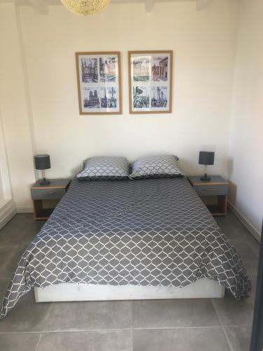 ein Schlafzimmer mit einem Bett mit zwei Nachttischen und zwei Lampen in der Unterkunft Agréable appartement à 2 pas des plages in Le Gosier