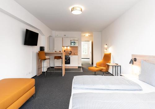 a hotel room with two beds and a kitchen at Apartimo Landshut in Landshut