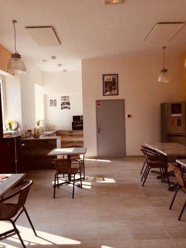 une pièce avec des tables et des chaises et une cuisine dans l'établissement L'auberge de Treigny, à Treigny