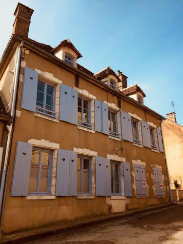 Un vieux bâtiment avec des volets bleus dessus dans l'établissement L'auberge de Treigny, à Treigny
