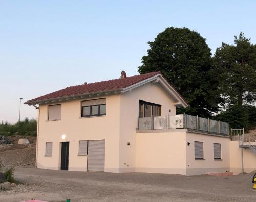 ein weißes Haus mit Balkon darüber in der Unterkunft Haus Märzenbach in Kaufbeuren