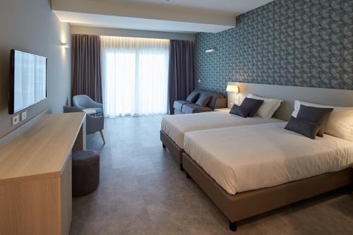 ein Hotelzimmer mit 2 Betten und einem TV in der Unterkunft Aldiana Club Calabria in Villapiana