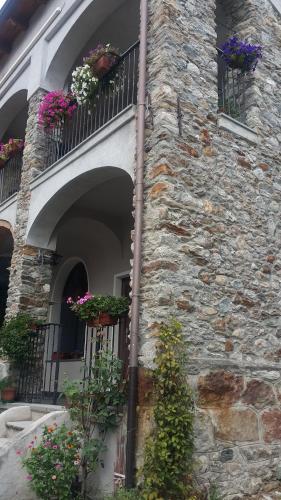 a stone building with flower boxes on the windows at Passaggio a Nord Ovest in Settimo Vittone