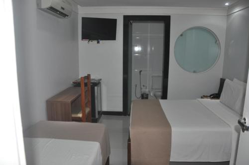 a bedroom with a bed and a sink and a mirror at Hotel Sempre Bahia in Salvador