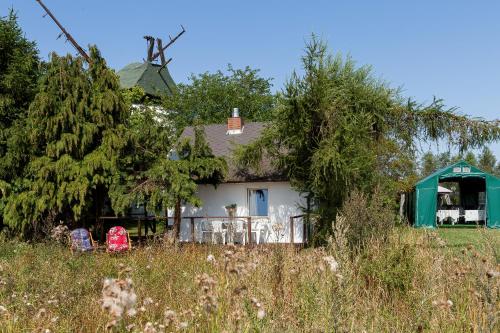 a white house with a green roof at Windmill vacation home in Ledzin near Baltic Sea in Niechorze