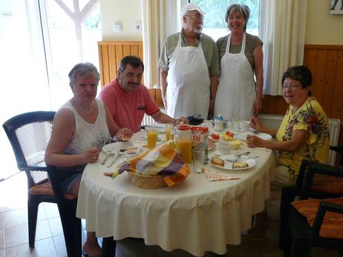 a group of people standing around a table with food at Mo-Ha Panzió in Törökszentmiklós