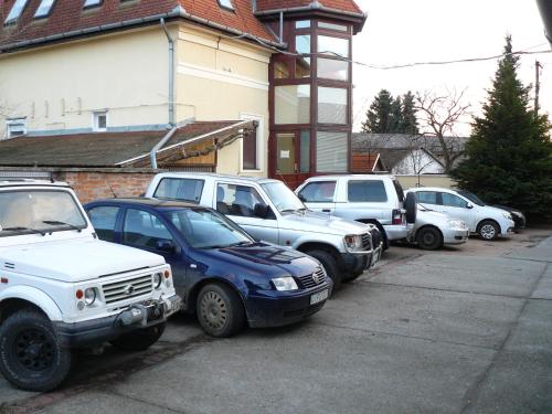 Une rangée de voitures garées sur un parking dans l'établissement Mo-Ha Panzió, à Törökszentmiklós