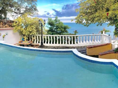 a swimming pool with a white fence next to the water at CafeGourmetPtaCorona in San Carlos