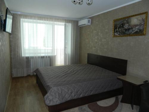 Schlafzimmer mit einem Bett und einem Fenster in der Unterkunft Соборная улица Апартаменты in Krementschuk