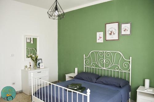 1 dormitorio con cama y pared verde en BICIaMICI Apartments, en Scafati