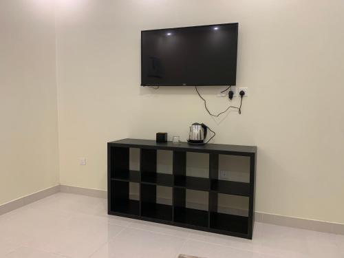 a flat screen tv hanging on a white wall at Economic Homes Apartments in Yanbu