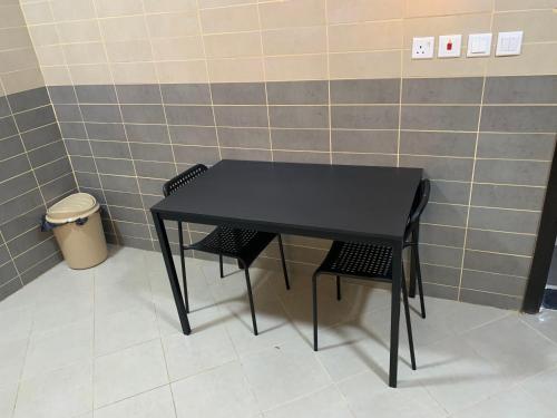 a black table and two chairs in a room at Economic Homes Apartments in Yanbu